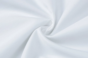 Detailaufnahme von weißem Textilgewebe mit weichen spiralförmigen Stofffalten