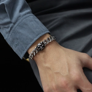 Mens silver stainless steel cuban link bracelet with detailed skull charm accent