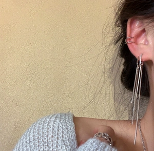 Detailed shot of elegant silver long tassel earrings and ear cuff with cubic zirconia