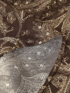 Detail shot of sheer chiffon fabric with paisley print and fine rolled edge stitching