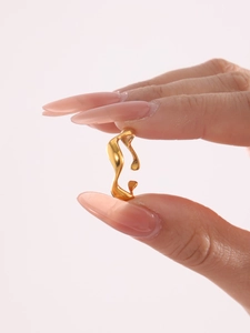 Detail view of gold molten lava ring showing irregular fluid curves and metallic finish