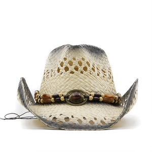 Detail of vintage straw cowboy hat with painted edges and ethnic beaded hat band