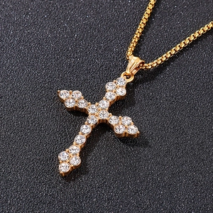 Vue macro du pendentif croix hip hop doré orné de strass blancs étincelants
