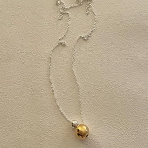 Detailed view of 925 silver necklace with two-tone gold and silver round bead pendants