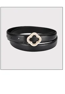 Detailed view of women's black leather belt featuring a gold clover buckle with rhinestones