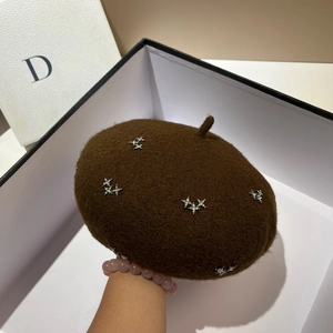 Detail of dark brown wool beret featuring shiny silver star rhinestones in a gift box