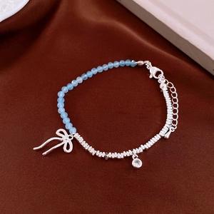 Detailed shot of bow crystal bracelet with light blue beads and silver metal cubes