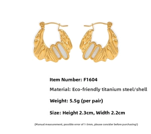 Detail view of irregular 18k gold lava texture earrings with white shell inlay