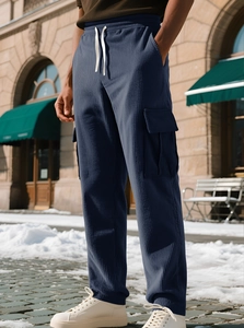Detail of dark blue corduroy pants featuring textured fabric and adjustable white drawstring