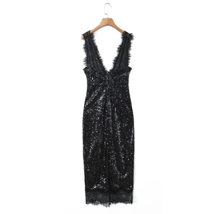 Détail d'une robe noire à paillettes avec col en V profond et bordure en dentelle