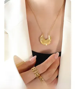 Detail of 18K gold-plated irregular hammered crescent necklace and double layer chain ring