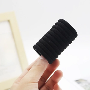 Stack of black high-elastic seamless hair ties held in hand for ponytail styling