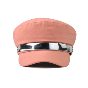 Close-up of coral pink newsboy hat with textured fabric and metallic silver M-embossed band