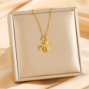 Elegant gold titanium steel bamboo pendant necklace with micro-pave diamonds on display