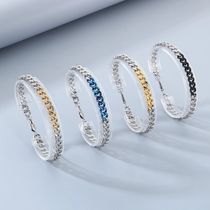 Detail of interlocking Cuban chain bracelets in silver with gold, blue, and black color accents