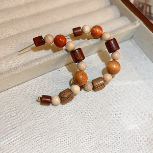 Detail view of vintage C-shaped wood beaded earrings with dark brown round beads