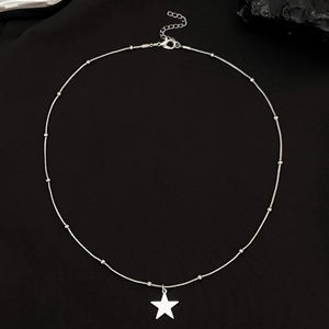 Minimalist silver star pendant necklace with delicate beaded chain on a black background