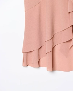Close-up of pink tiered ruffle layers and textured knit fabric on women halter top