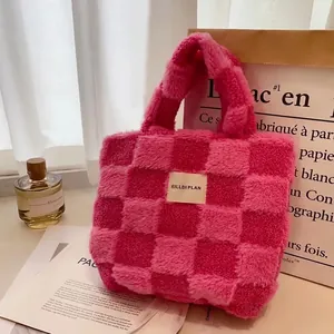 Pink and beige waffle checkerboard faux fur bucket bag with brand label on surface