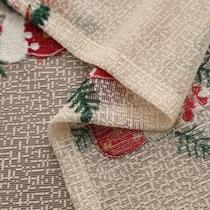 Detail of Christmas tablecloth showing rustic woven texture and red embroidered trees