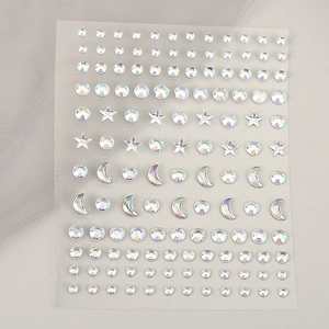 Macro view of holographic star and moon face gems on a self-adhesive sheet