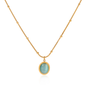 Macro shot of gold-plated snake chain necklace featuring a blue cat-eye stone pendant