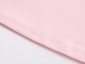Detail of pink knitted fabric showing reinforced double-needle stitched hem on workout tank