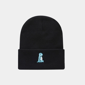 Close-up of a black ribbed knit beanie featuring a cute blue dinosaur embroidery