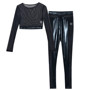 Detailed flat lay of black two-piece set featuring mesh patchwork and glossy panels