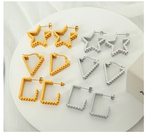 Macro view of gold and silver geometric star, triangle, and rectangle stud earrings