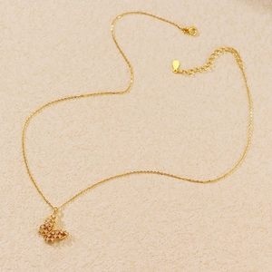 Macro view of gold butterfly pendant with lattice pattern and sparkling diamonds