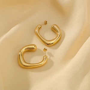 French style 18k gold plated stainless steel C-shape earrings on silk background