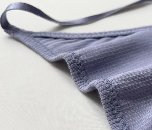 Macro shot of purple ribbed cotton thong showing fine stitching and elastic straps