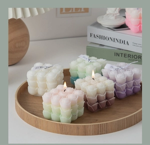 Macro shot of rose cube scented candles in various colors on a wooden tray with soft lighting