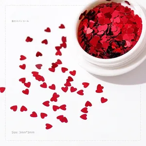 Macro shot of 3mm red heart nail art sequins in a round container for manicures