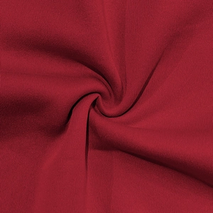 Close-up of deep red ribbed fabric texture showing knit patterns on slim casual jacket