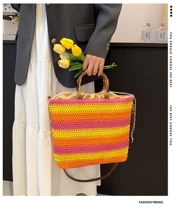 Detail of woven beach bag with bamboo handle, drawstring liner and shoulder strap