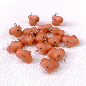 Macro view of brown resin capybara pendants with silver metal loops for DIY crafts