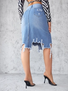 Detail of high-waist denim skirt featuring frayed hem and back pockets on light blue fabric