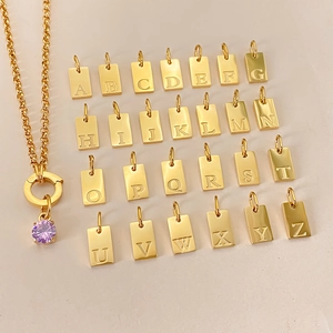 Detailed view of gold stainless steel necklace with 26 alphabet pendants and purple charm.