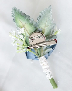 Detail of light blue rose boutonniere featuring a secure silver safety pin and crocodile clip