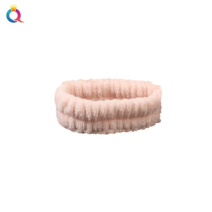 Close-up of pink coral fleece headband with soft vertical striped texture for face washing