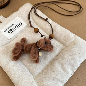 Macro detail of plush poodle pendant with brown leather cord and wooden beads