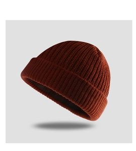 Close-up of rust red ribbed knit texture on a high-quality minimalist beanie hat