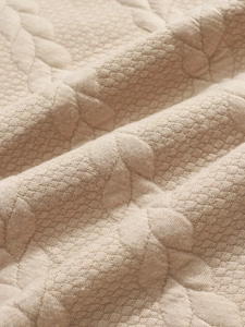 Macro shot of heavy jacquard knit fabric with honeycomb texture in beige