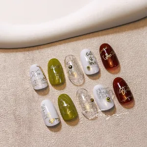 Detail of premium 3D relief nail art stickers featuring olive green and gold accents