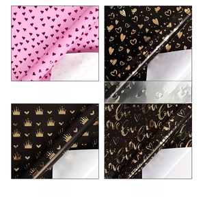 Detailed views of heart and crown patterned gift wrapping paper with metallic gold foil finish