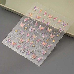 Macro detail of 5D gold bronzing butterfly and moon nail art stickers on a clear film