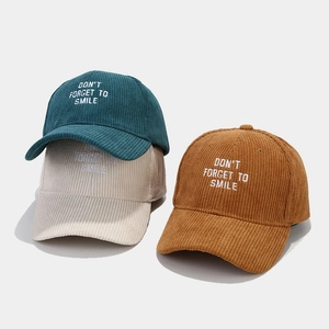 Corduroy baseball caps with letter embroidery in dark green, off-white, and caramel brown