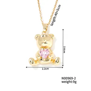 Detail view of a golden teddy bear pendant with a pink heart zircon and size dimensions